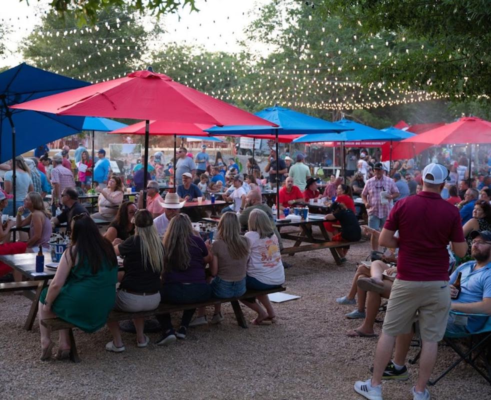Union 28 outdoor venue with red and blue umbrellas, live music, string lights, packed crowd